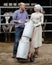 Two happy farmers holding a trolley with milk