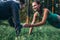 Two happy friends holding hands while doing plank exercise in park