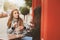 Two happy girl friends talking and drinking coffee in autumn city in cafe. Meeting of good friends, young fashionable students