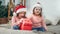 Two happy girl in Santa Claus cap surprising opening Christmas gift box having positive emotion