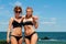 Two happy girls in bikini on the beach. Best friends having fun, summer vacation holiday lifestyle.