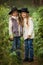 Two happy girls are equally dressed: in fur vests and hats in the forest. Little girlfriends in park.