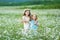 Two happy girls in field. Sisters enjoy summer time vacation in village