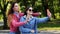 Two happy girls friends make selfie on the mobile phone on the city park