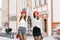 Two happy girls girlfriends hold hands and raised them up, they are smiling. Brunette and brown-haired woman in red berets