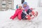 Two happy girls slide down the icy hill