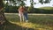 Two happy girls swinging outdoors - camera in low angle rising