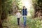 Two happy kids walking along forest path