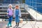 Two happy laughing children with fishing rods and a bucket on a fishing trip on a wooden pontoon on a fish farm