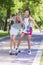 Two Happy Laughing Teenager Girls Skating Longboard Together in Park