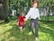 Two happy little girls catch soap bubbles among trees