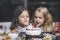 Two happy little girls child celebrating a birthday with cake at