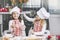 Two happy little girls child cook with flour and dough at the ta