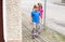 Two happy little girls, school age children walking on the sidewalk near a street on their own Young kids, siblings or friends