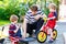 Two happy little kid boys and father repair chain on bikes and change wheel of balance bicycle