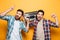 Two happy men in shirts listening music by record player