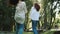 Two happy pretty girlfriends are dancing and jumping on the grass, posing for the camera on a warm sunny day. Fun photo