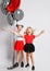 Two happy screaming singing kids girls in skirts and t-shirts with air balloons stand together with arms outstretched