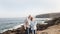 Two happy senior people standing on the cliff of the ocean.Hugging and smiling. Morning soon outdoor with clear sky. Vacation and