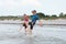 Two happy siblings children in neoprene swimingsuit  playin and running in sea