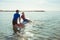 Two happy siblings teen children in neoprene suits having fun  with sup board in Baltic sea