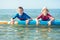 Two happy siblings teen children in neoprene suits having fun  with sup board in Baltic sea