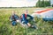Two happy skydivers in a jumpsuits sitting on grass. Two skydivers landed on the grass field
