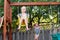 Two happy smiling little girls on swing on backyard playground outside on summer day