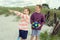 Two happy teen children on beach with white sand and dunes on Baltic sea at summer holidays