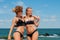 Two happy women in bikini on the beach. Best friends having fun, summer vacation holiday lifestyle.