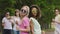 Two happy women dancing with friends at pool party, enjoying life, slow motion