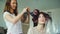 Two happy women friends make fun curler hairstyle each other and have fun at home