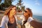 Two happy women girlfriends lesbian couple laughing while spending time on the beach, summer vacation. Happy people concept