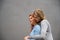 Two happy women hugging against the background of a gray wall. Gentle hugs of a female lesbian couple. LGBT Same-sex