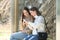 Two happy women waiting in a bus stop checking phones