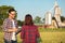 Two happy young female and male farmers or agronomists talking in a wheat field, consulting and discussing