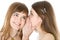 Two happy young girlfriends telling secret