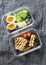 Two healthy office lunch box with sweet and savoury food. Boiled egg, avocado, tuna spinach cheese sandwiches and fruit