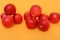 Two heap of red apples on a ornage background