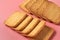 Two heaps of whole square cookies lies on pink desk on kitchen