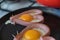 Two heart-shaped sausages and sunny side up eggs in a pan. Cooking. Love, relationship concept. Close-up. Selective focus