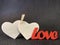 Two hearts are clamped by a clothespin on a dark background. Sign: love and fidelity for two. Concept: symbolism of love and