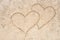 Two hearts drawing in sand