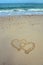Two hearts drawn in sand