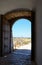 Two Heavy Wooden Doors looking Through an Archway