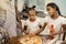 Two helpful girls spreading tomato sauce while cooking pizza