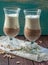 Two high glasses with appetizing and healthy dessert which consists of fresh soft cream (vanilla and chocolate)
