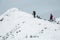 Two hikers alpinist climbing up the snowy mountain on Sunset. Alpine winter view. Carpathians, Marmarosy