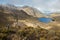 Two hikers contemplating the landscape full of paramo vegetation with rocks and a beautiful lake in the Chirripo National Park in