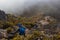 Two hikers descending the rocky mountain with mist clouds on top of Cerro Chirripo in Chirripo National Park in Costa Rica